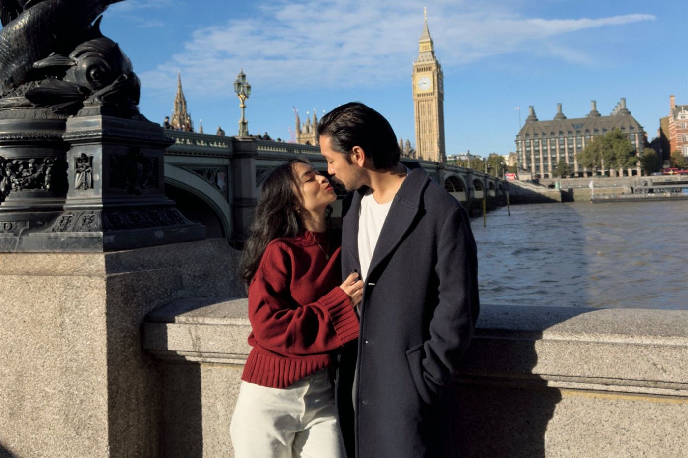 Michelle and Andrew leaning in for a kiss by the Thames, with Big Ben behind them